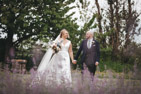 wedding couple walking through the gardens at Tickton Grange with lavender flowers in the foreground