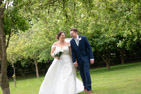 Megan and james - wedding couple walking through the orchard  their wedding at the Barn at Willerby